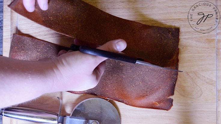 Cutting the fruit leather with kitchen scissors.