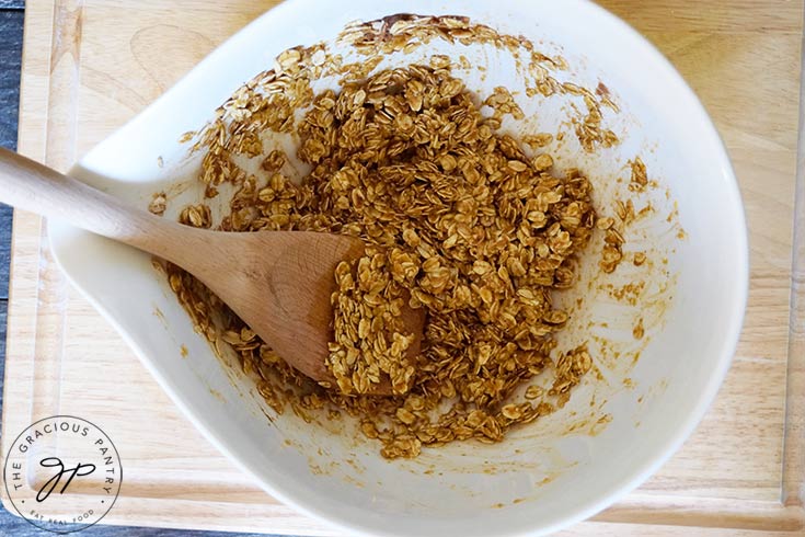 All the ingredients for this Pumpkin Granola Recipe mixed together in a white mixing bowl.