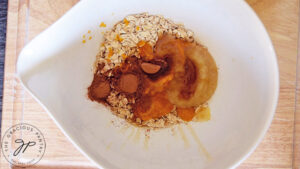 All the ingredients for this Pumpkin Granola Recipe in a mixing bowl.