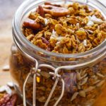 A close up view of an open jar filled with this Pumpkin Granola Recipe.