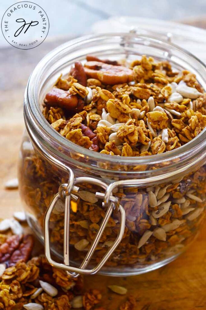 A close up view of an open jar filled with this Pumpkin Granola Recipe.