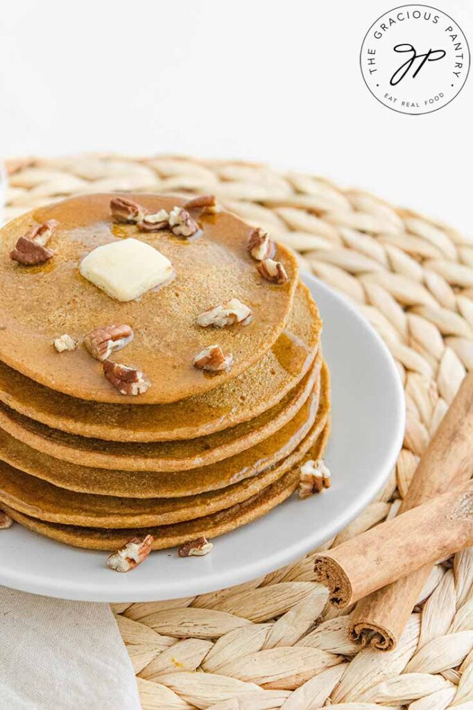 An overhead view looking down on a pat of melting butter on top of a stack of Pumpkin Oatmeal Pancakes.