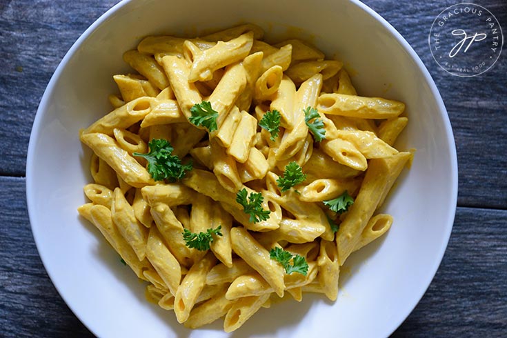 The finished Pumpkin Pasta Sauce on pasta that is garnished with fresh parsley.