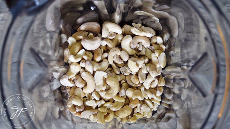 The soaked cashews sitting in a blender cup.