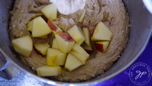 Stirring the apples into the batter.