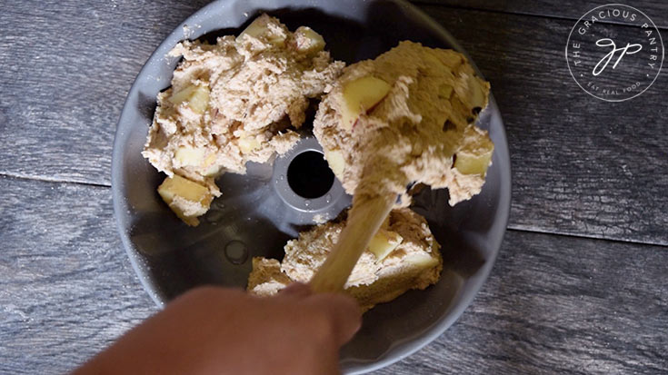 Spooning the cake batter into the bundt pan.