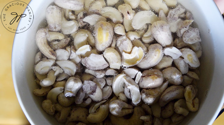 Cashews soaking in a bowl of water.