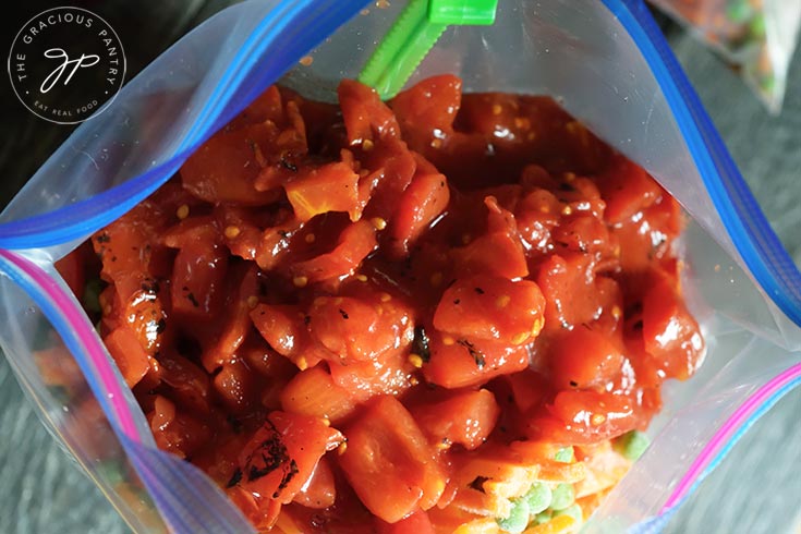 Diced tomatoes added to the freezer bag.
