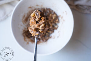 The topping ingredients for this Healthy Sweet Potato Casserole Recipe mixed together. A spoon lifts some towards the camera.