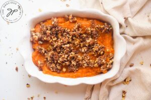 The topping sprinkled over the top of the Healthy Sweet Potato Casserole, in a white casserole dish.