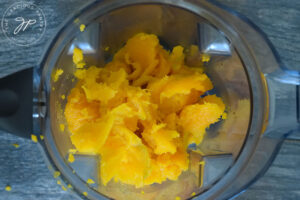 The flesh of a kabocha squash scrapped out of the skin and sitting in a blender.