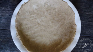 A prepared pie crust in a white pie pan.