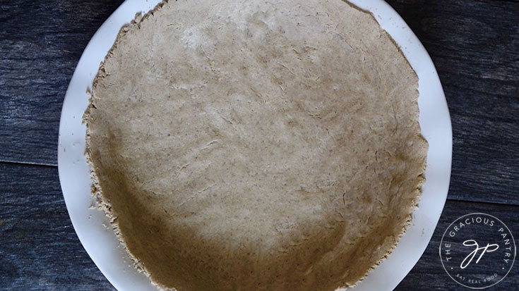 A prepared pie crust in a white pie pan.