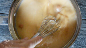 Whisking the milk, pumpkin and sweetener together in a pot.