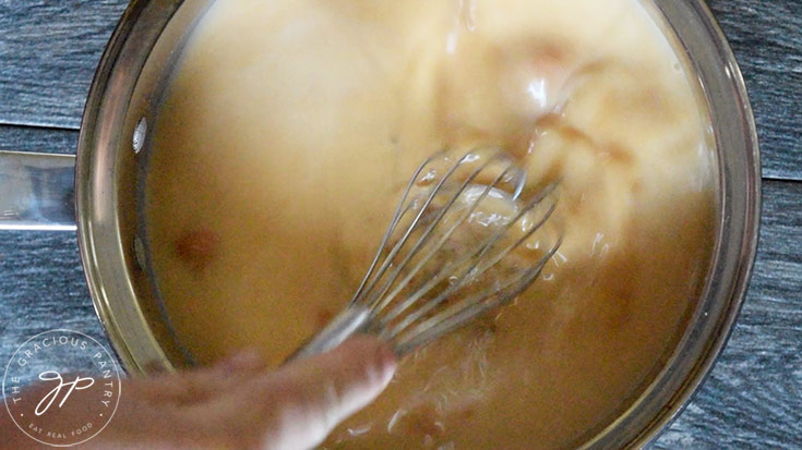 Whisking the milk, pumpkin and sweetener together in a pot.