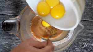 Tempering the eggs in a large measuring cup.