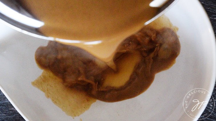 Pouring the finished ice cream base into a large, white bowl.