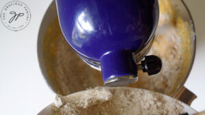 Pouring flour into the wet batter.