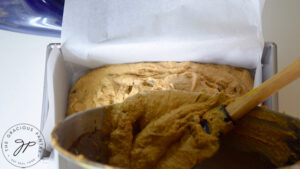 Pouring the Snickerdoodle Pumpkin Bread batter into the lined loaf pan.