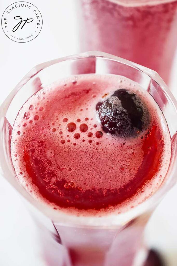 An up close shot of a single wine glass filled with Cranberry Mimosa Mocktail.