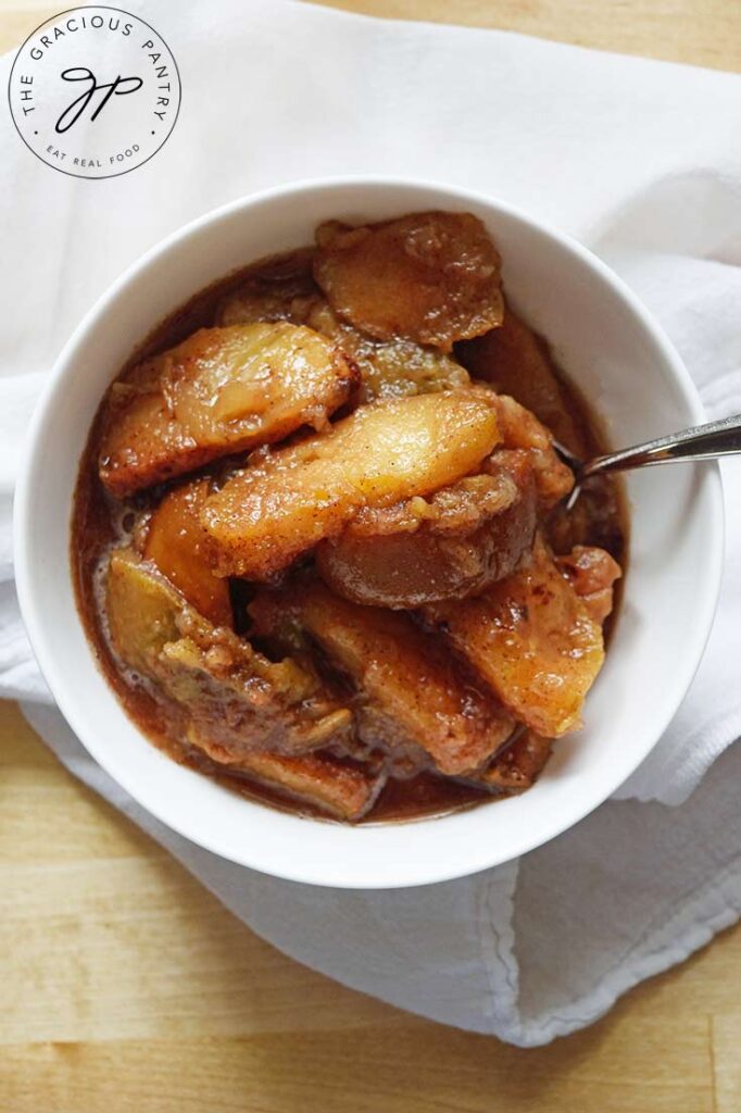 An overhead view looking down into a white bowl filled with Crockpot Cinnamon Apples