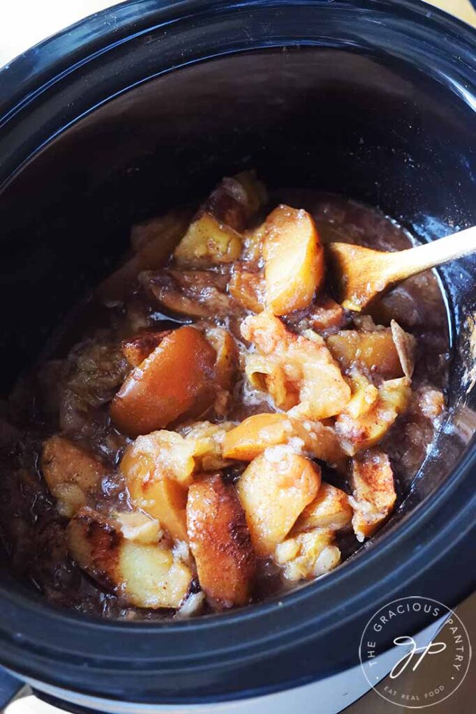 A black crock filled with just-cooked Crockpot Cinnamon Apples.