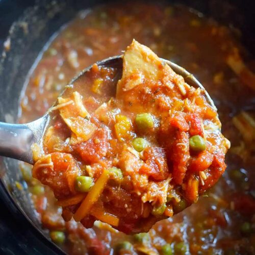 A ladle lifts a scoop of this Crockpot Italian Chicken Recipe out of the crockpot and towards the camera.