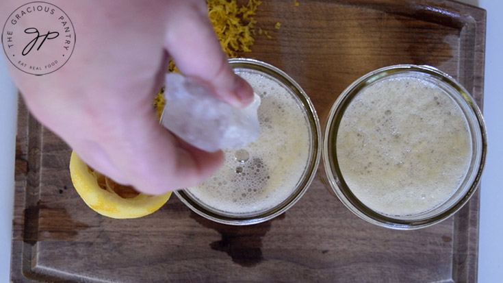 Adding ice cubes to two glasses filled with this Lemon Drop Mocktail Recipe.
