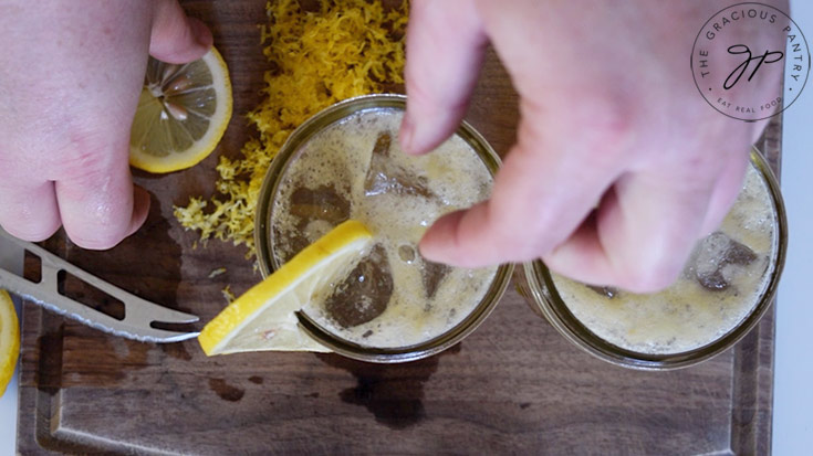 Adding lemon garnish to to glasses filled with this Lemon Drop Mocktail Recipe.