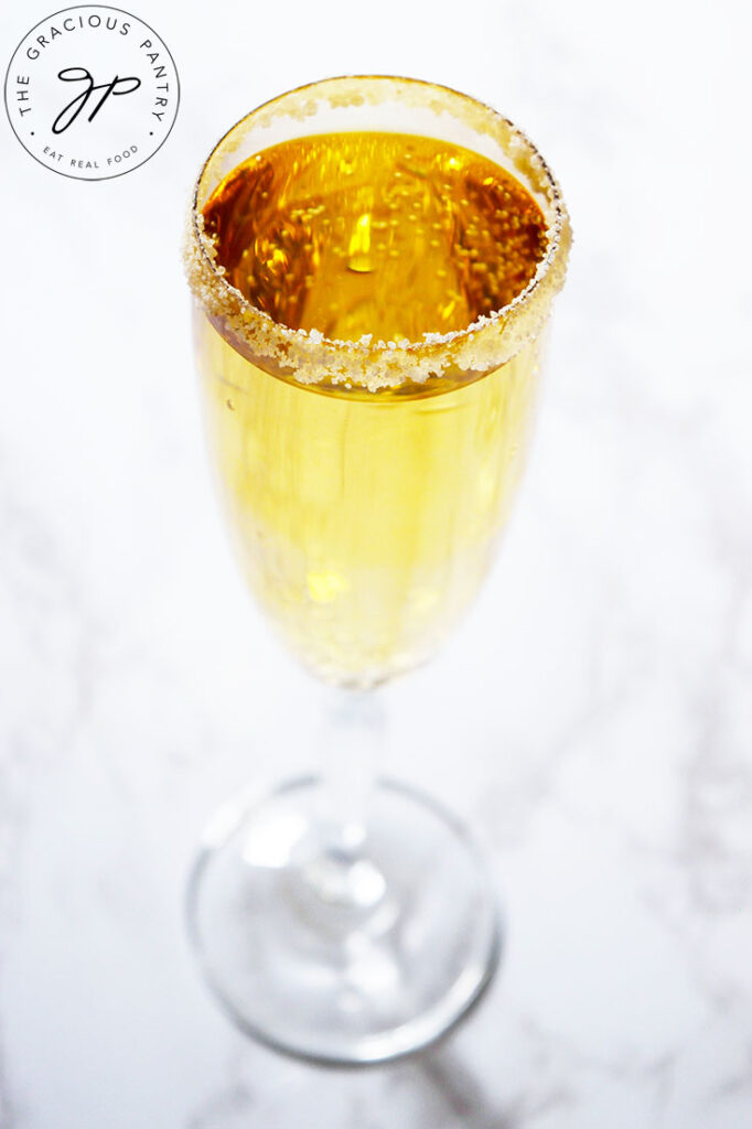 A single champagne glass filled with Mock Champagne on a white background.