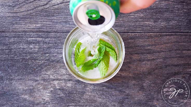 Pouring ginger ale from a can into a canning jar.