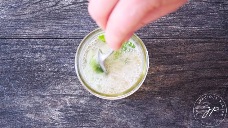 Stirring all the drink ingredients together in a canning jar.