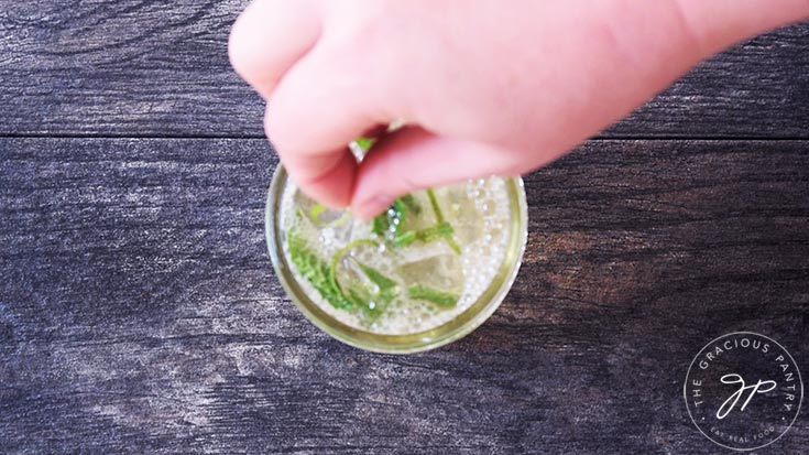 Garnishing the mojito mocktail with lime zest.