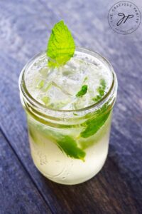 A side view of a mojito mocktail in a canning jar.