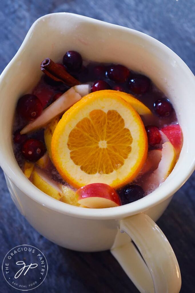 A large, ceramic pitcher filled with Non Alcoholic Sangria.