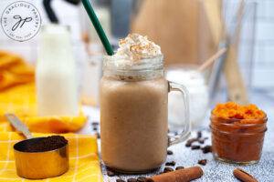 The finished Sugar Free Pumpkin Spice Coffee Creamer mixed into a latte, topped with whipped cream and cinnamon in a glass mug.