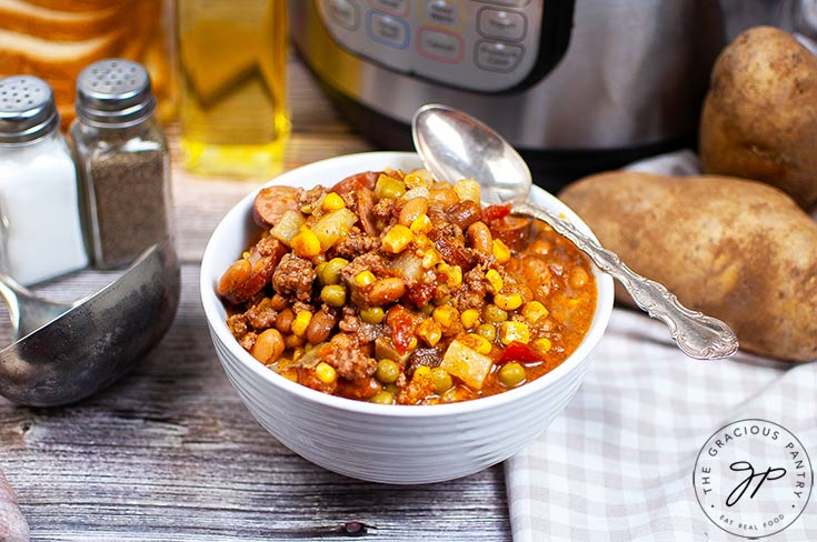 The finished Instant Pot Texas Cowboy Stew Recipe served in a white bowl with a spoon.