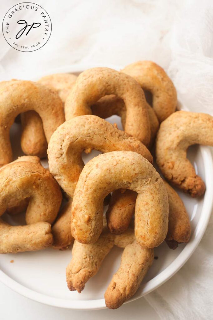 An overhead view looking down on a white plate of Almond Horn cookies.