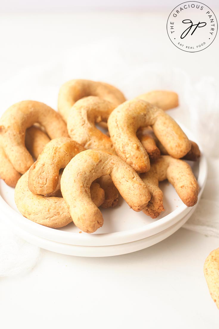 A front view of a white plate piled high with Almond Horns.