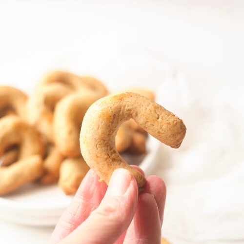 A woman's hand holds up an Almond Horn to the camera.