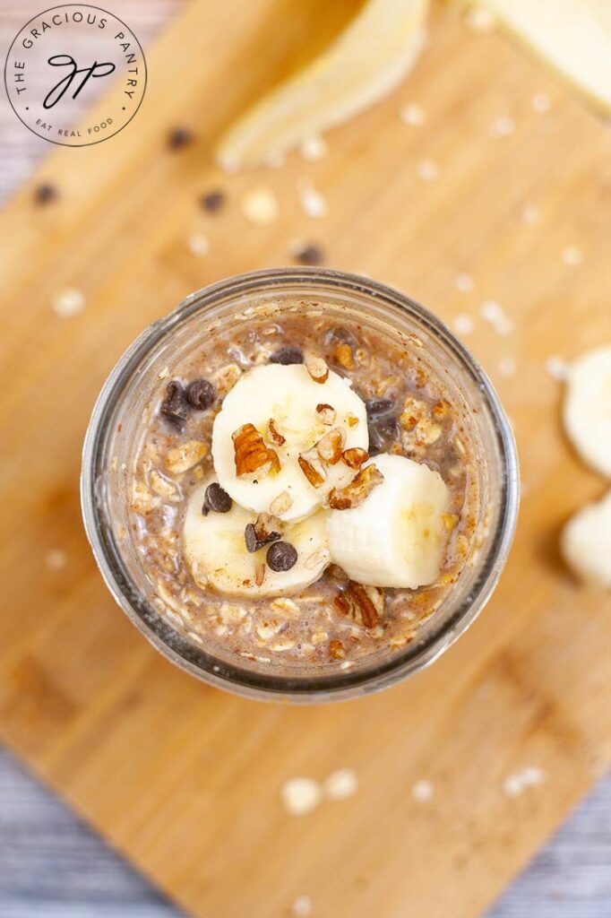 The finished Banana Bread Oatmeal Recipe in a canning jar topped with sliced bananas.