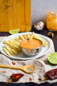 A plate of fries holding a small, stainless steel bowl filled with Chipotle Aioli.