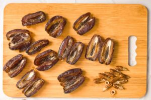 Cut and pitted dates laying open on a cutting board.