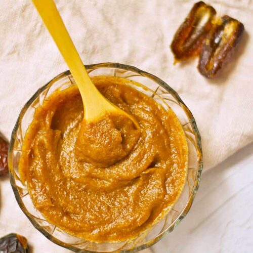 And overhead view looking down into a bowl of Date Caramel. Pitted dates lay around the base of the bowl.