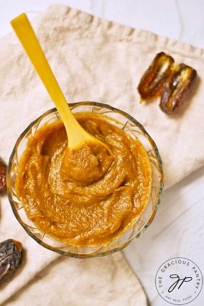 And overhead view looking down into a bowl of Date Caramel. Pitted dates lay around the base of the bowl.