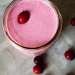 An overhead view looking down into a canning jar glass filled with this Fresh Cranberry Smoothie Recipe