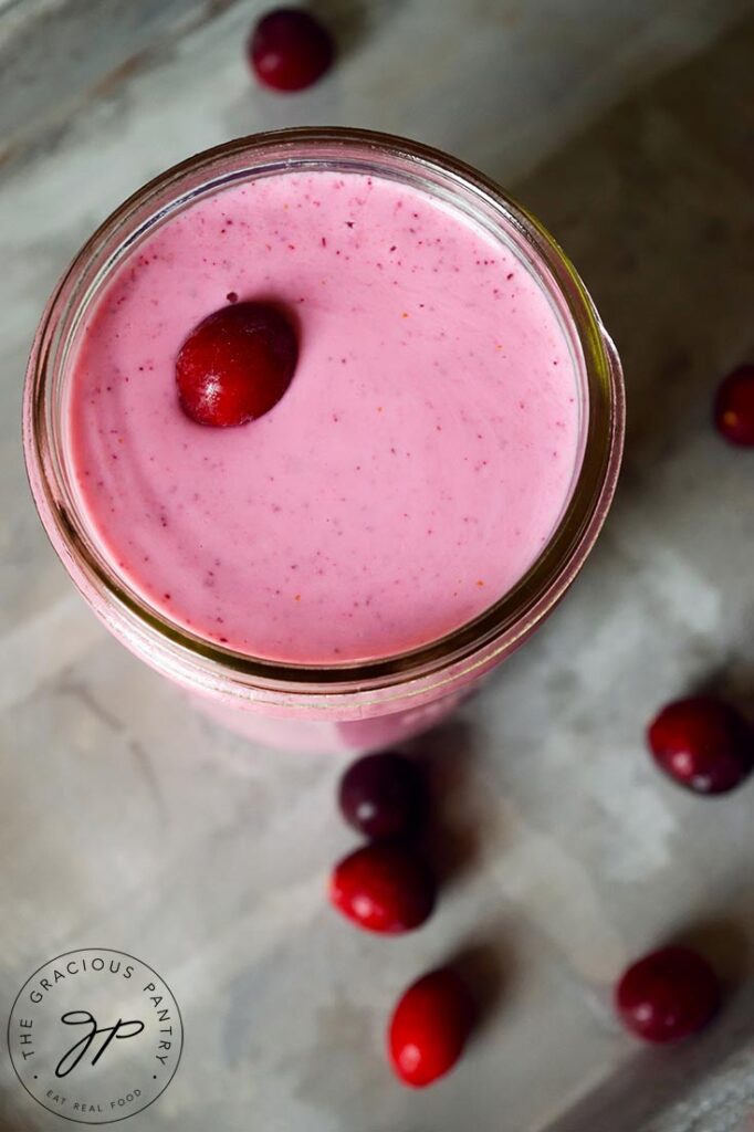 An overhead view looking down into a canning jar glass filled with this Fresh Cranberry Smoothie Recipe