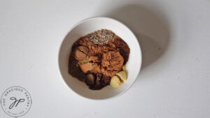 The individual gingerbread spices sitting in a small white bowl.