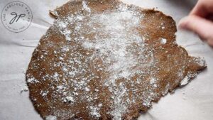 Dusting rolled gingerbread dough with flour before cutting.