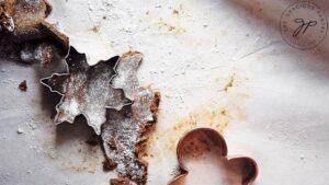 Cutting gingerbread dough with cookie cutters.